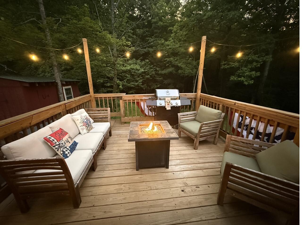 The back deck at night with a firepit and string lights